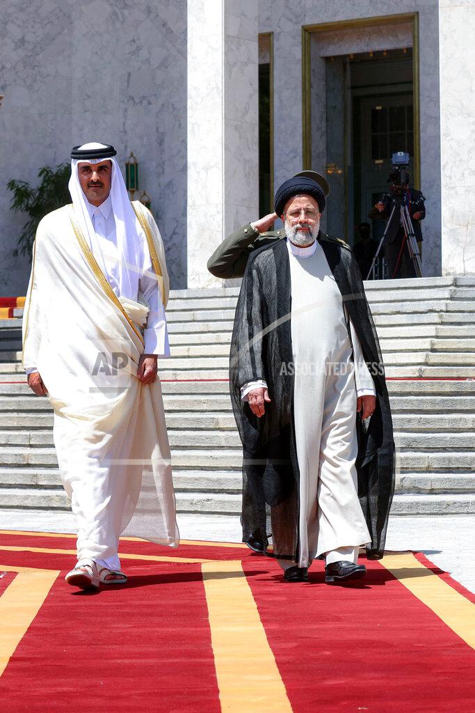 Uncredited In this photo released by the official website of the office of the Iranian Presidency, Qatari Emir Sheikh Tamim bin Hamad Al Thani, left, is welcomed by President Ebrahim Raisi during an official arrival ceremony at the Saadabad Palace in Tehran, Iran, Thursday, May 12, 2022. Qatar's emir arrived in Tehran for talks with the Iranian president as efforts to save Tehran's tattered nuclear deal with world powers hit a deadlock. (Iranian Presidency Office via AP)