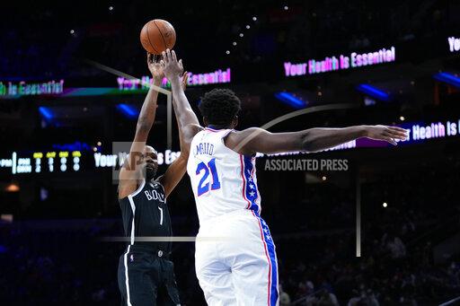 Brooklyn Nets' Kevin Durant, left, goes up for a shot against Philadelphia 76ers' Joel Embiid during the first half of a preseason NBA basketball game, Monday, Oct. 11, 2021, in Philadelphia. (AP Photo/Matt Slocum)
