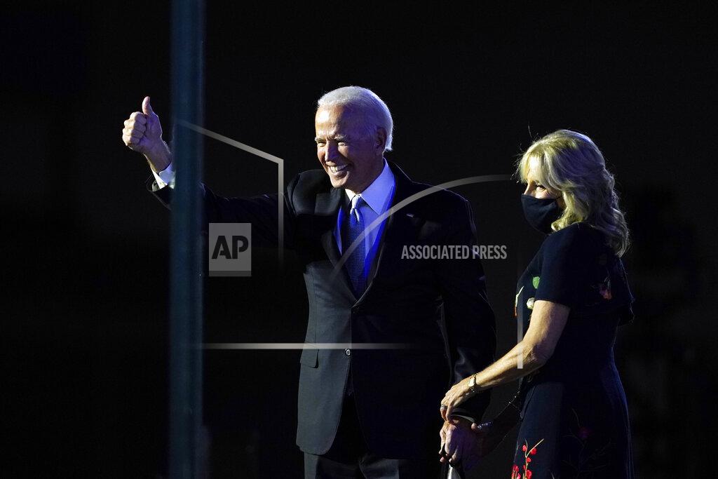 Carolyn Kaster President-elect Joe Biden stands on stage with his wife Jill Biden as he gives the thumbs-up to the cheering crowd beyond the protective glass, Saturday, Nov. 7, 2020, in Wilmington, Del. (AP Photo/Carolyn Kaster)