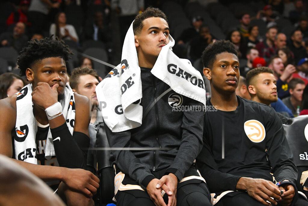 John Amis Atlanta Hawks forward Cam Reddish, left, guard Trae Young, center, and forward De'Andre Hunter, right, watch the final moments of an NBA basketball game against the Detroit Pistons from the bench, Saturday, Jan. 18, 2020, in Atlanta. (AP Photo/John Amis)