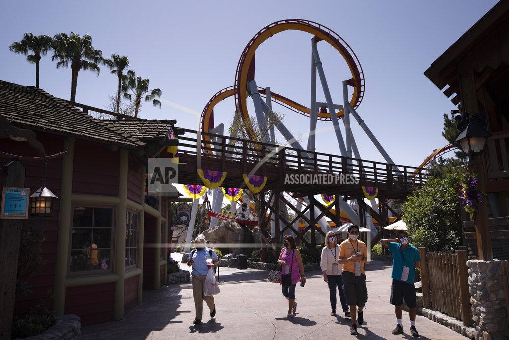 Jae C. Hong Visitors with face masks attend the Knott's Taste of Boysenberry Festival at Knott's Berry Farm in Buena Park, Calif., Tuesday, March 30, 2021. Massive Los Angeles County can reopen even more businesses, California public health officials announced Tuesday. The county of 10 million people was one of several counties, including neighboring Orange County, that moved into the state's second-least restrictive orange tier amid low coronavirus case rates. (AP Photo/Jae C. Hong)