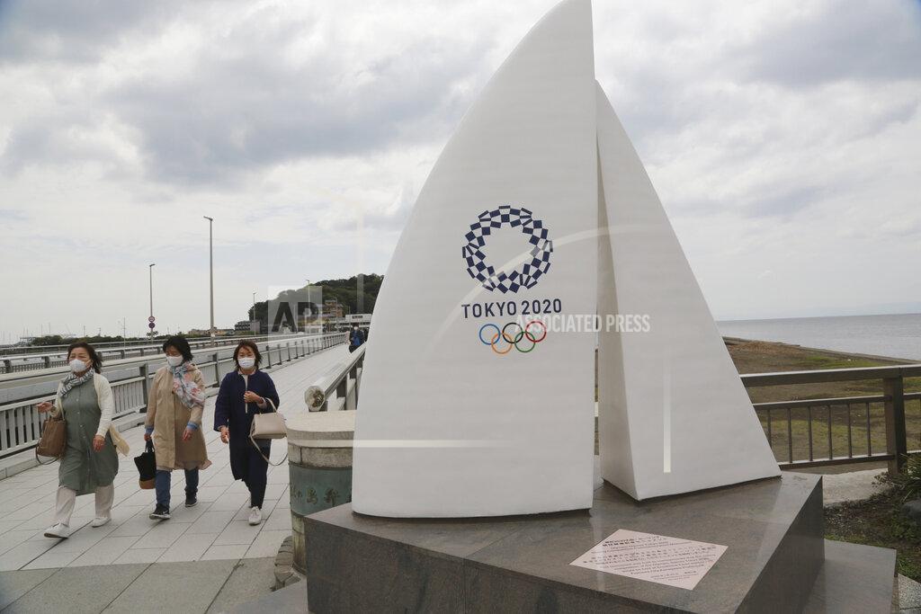 Koji Sasahara People wearing face masks to protect against the spread of the new coronavirus walk at Enoshima, the venue of sailing competitions at the Tokyo 2020 Olympics, in Fujisawa, near Tokyo, Tuesday, April 6, 2021. Many preparations are still up in the air as organizers try to figure out how to hold the postponed games in the middle of a pandemic. (AP Photo/Koji Sasahara)