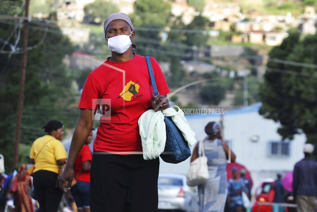 Neo Ntsoma Matefo Litali, 53, a garment worker and staunch supporter of Lesotho Workers Party (LWP), walks down a street in Maseru, Lesotho, on Friday, Dec. 11, 2020. She recently landed a job sewing jeans at Presitex after surviving months of unemployment during the widespread layoffs and suspensions of employees at the beginning of the coronavirus pandemic in March. (Neo Ntsoma/The Fuller Project via AP)