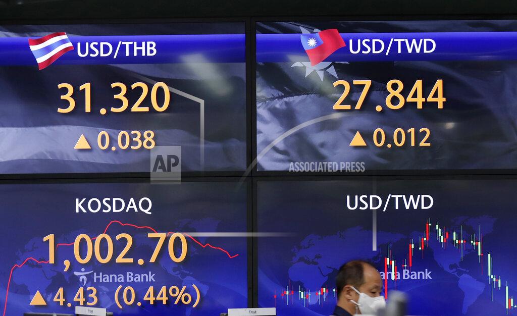 Lee Jin-Man A currency trader walks near near the screens showing the Korean Securities Dealers Automated Quotations (KOSDAQ), left bottom, and the foreign exchange rates at the foreign exchange dealing room in Seoul, South Korea, Thursday, April 29, 2021. Asian shares rose Thursday and U.S. futures also were higher after President Joe Biden delivered a speech to Congress that outlined ambitious plans for jobs creating spending on early education, child care and other public services. (AP Photo/Lee Jin-man)