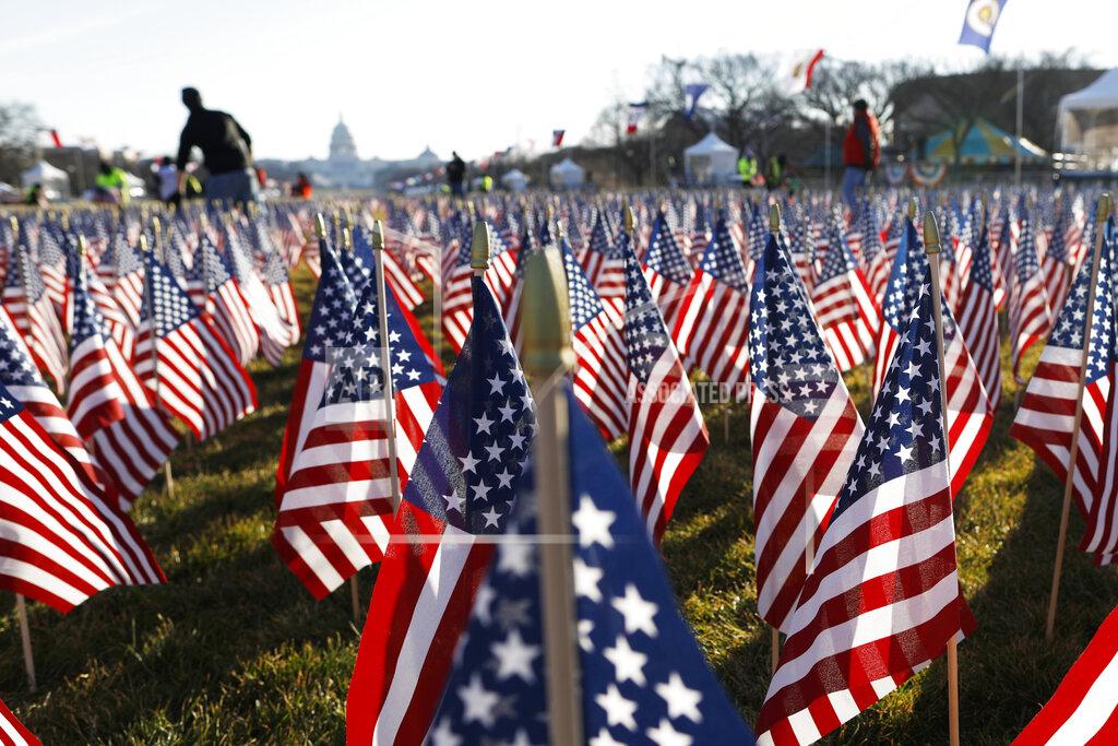 Rebecca Blackwell FILE - In this Jan. 21, 2021, file photo workers begin to remove a display of flags on the National Mall one day after the inauguration of President Joe Biden in Washington. As one of his first acts, Biden offered a sweeping immigration overhaul that would provide a path to U.S. citizenship for the estimated 11 million people who are in the United States illegally. It would also codify provisions wiping out some of President Donald Trump's signature hard-line policies, including trying to end existing, protected legal status for many immigrants brought to the U.S. as children and crackdowns on asylum rules. (AP Photo/Rebecca Blackwell, File)