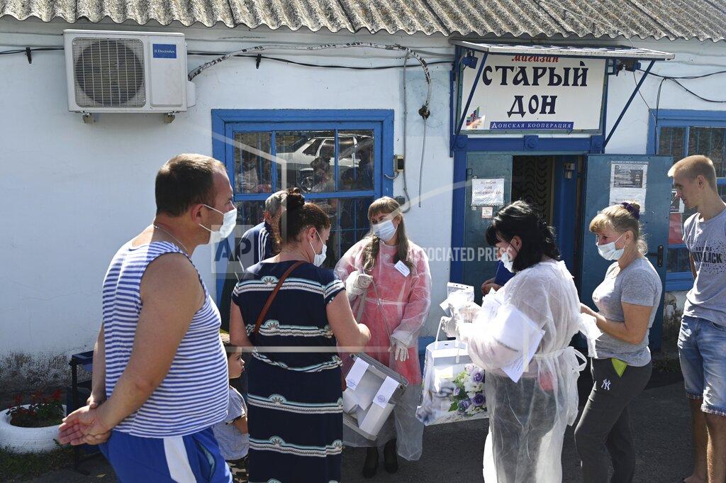 Uncredited Villagers cast their ballots in a street of Starozolotovsky village, 160 km (100 miles) north of Rostov-on-Don during the Parliamentary elections, Russia, Saturday, Sept. 18, 2021. Sunday is the last of three days voting for a new parliament, but there seems to be no expectation that United Russia, the party devoted to President Vladimir Putin, will lose its dominance in the State Duma. (AP Photo)