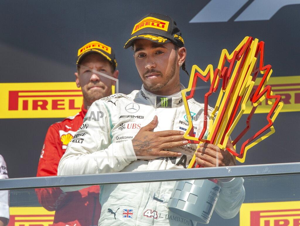 Ryan Remiorz Mercedes driver Lewis Hamilton, front, of Britain, salutes the crowd after winning the Formula One Canadian Grand Prix auto race as second-place finisher Ferrari driver Sebastian Vettel, of Germany, looks on Sunday, June 9, 2019, in Montreal. (Ryan Remiorz/The Canadian Press via AP)