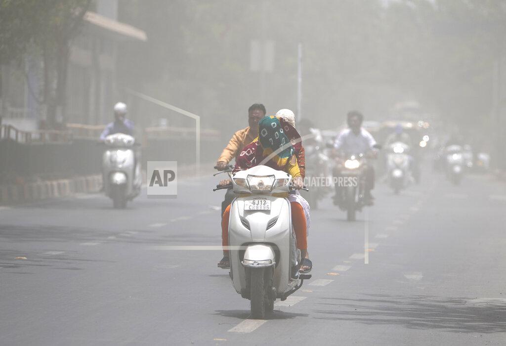 Ajit Solanki A woman covers her face with a scarf to protect from heat wave rides through a dust storm in Ahmedabad, India, Saturday, May 21, 2022. The intense heat wave sweeping through South Asia was made more likely due to climate change and it is a sign of things to come. An analysis by international scientists said that this heat wave was made 30-times more likely because of climate change, and future warming would make heat waves more common and hotter in the future. (AP Photo/Ajit Solanki)