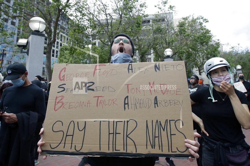 Jeff Chiu Nolan Ramirez holds up a sign at protest over the Memorial Day death of George Floyd, a handcuffed black man in police custody in Minneapolis, in San Francisco, Saturday, May 30, 2020. (AP Photo/Jeff Chiu)