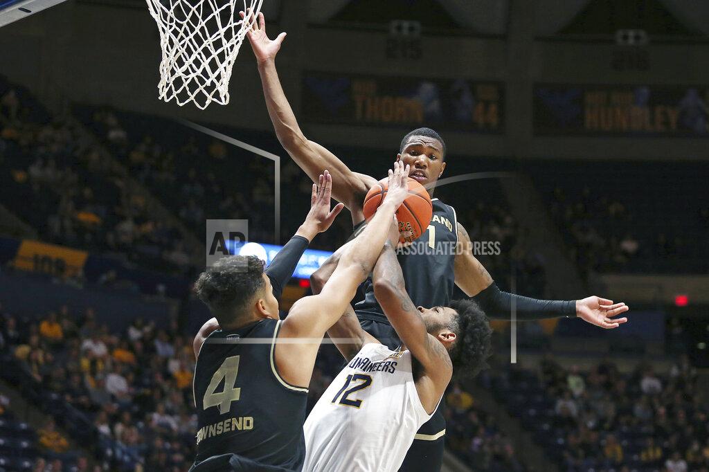 Kathleen Batten West Virginia guard Taz Sherman (12) shoots as Oakland forwards Trey Townsend (4) and Jamal Cain (1) defend during the second half of an NCAA college basketball game in Morgantown, W.Va., Tuesday, Nov. 9, 2021. (AP Photo/Kathleen Batten)
