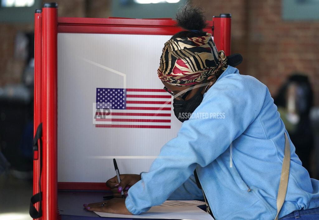 Darron Cummings FILE - In this Tuesday, Nov. 3, 2020, file photo, Johnea Barlow casts her ballot at the Kentucky Center for African American Heritage, on Election Day in Louisville, Ky. The 2020 presidential election had all the makings of a looming disaster: fears of Russian meddling, violence at the polls, voter intimidation and poll workers fleeing their posts over the coronavirus. But the election was largely smooth, in large part because 107 million voters that cast their ballots early and took the pressure off Election Day operations. (AP Photo/Darron Cummings, File)