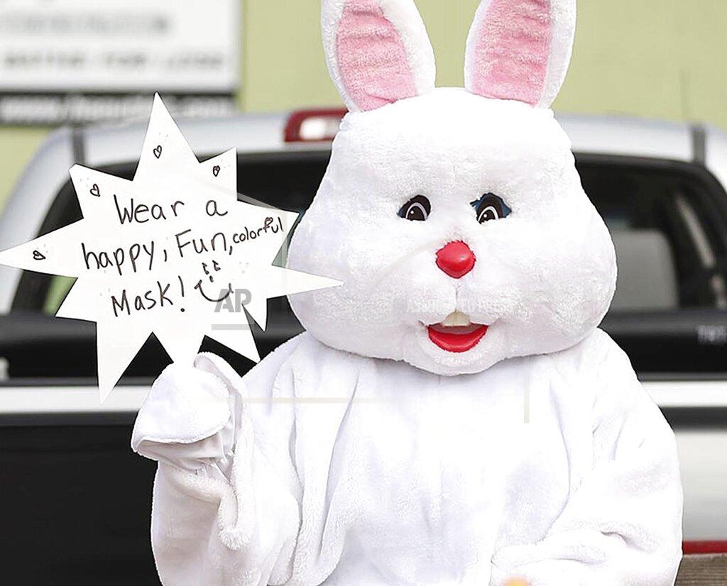 Stephen M. Dowell The Easter Bunny encourages people to wear a mask during an Easter parade in Orlando, Fla., on Saturday, April 11, 2020. The parade, conducted with "social distancing" to prevent the spread of coronavirus. (Stephen M. Dowell/Orlando Sentinel via AP)