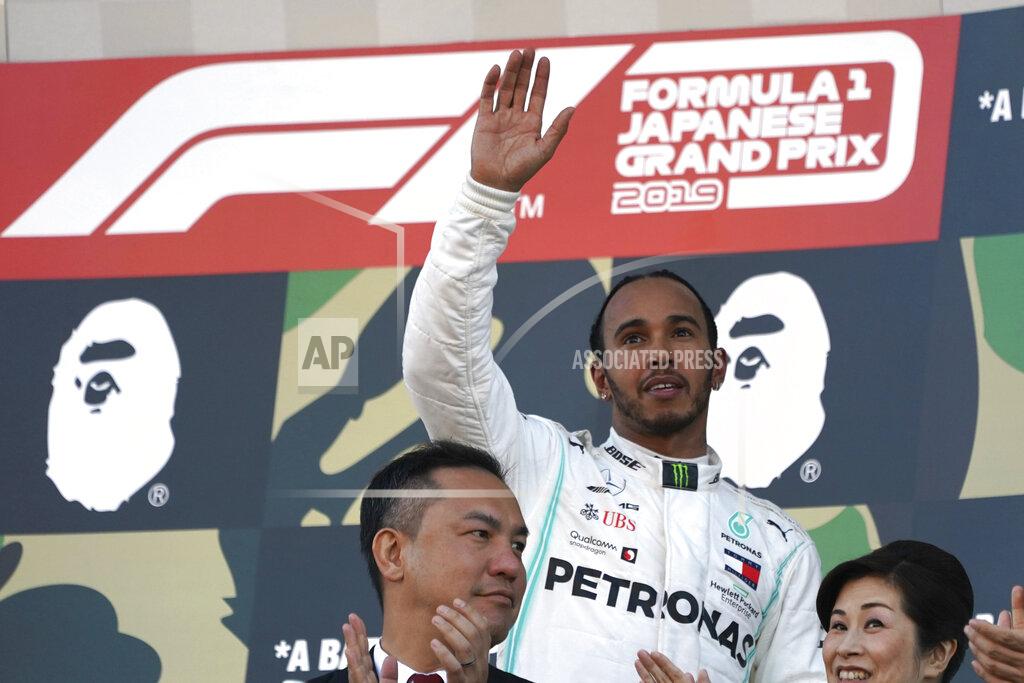 Mercedes driver Lewis Hamilton of Britain waves on the podium after finishing third in the Japanese Formula One Grand Prix at Suzuka Circuit in Suzuka, central Japan, Sunday, Oct. 13, 2019. (AP Photo/Toru Hanai)