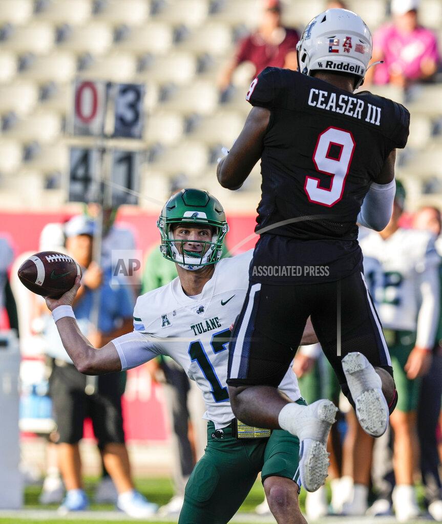 Brett Coomer Tulane quarterback Kai Horton (12) passes the ball around the leaping Houston defensive lineman Nelson Ceaser (9) during the first quarter of an NCAA college football game Friday, Sept. 30, 2022, in Houston. (Brett Coomer/Houston Chronicle via AP)