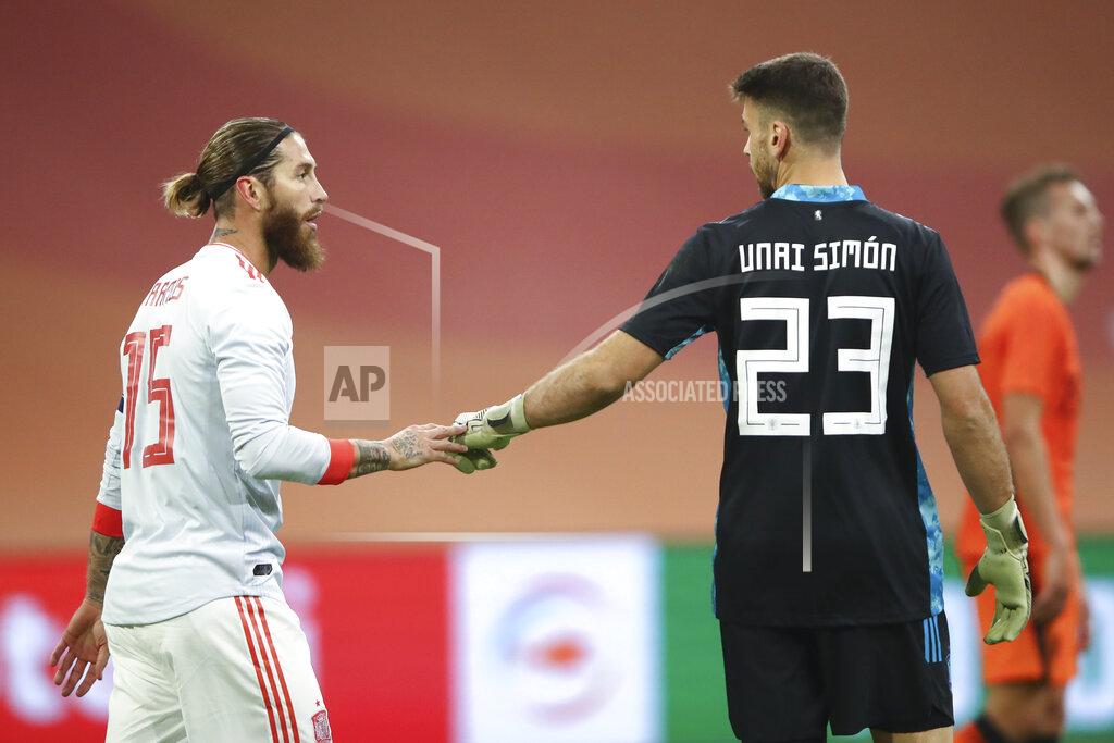 Dean Mouhtaropoulos Spain's Sergio Ramos, left, and Spain's goalkeeper Unai Simon, right, talks after the international friendly soccer match between The Netherlands and Spain at the Johan Cruyff ArenA in Amsterdam, Netherlands, Wednesday, Nov. 11, 2020. Ramos came on as an 85th-minute substitute for his 176th international, drawing level with former Italy goalkeeper Gianluigi Buffon as the European with the most caps. The world record is Ahmed Hassan's 184 for Egypt. (Dean Mouhtaropoulos/Pool via AP)