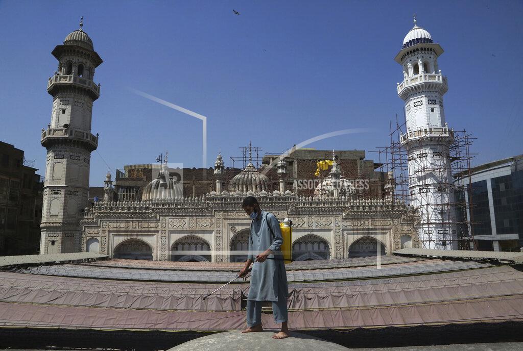 Muhammad Sajjad A volunteer disinfects the outer area of a historical Mohabat Khan mosque ahead of the upcoming Muslim fasting month of Ramadan, in Peshawar, Pakistan, Friday, April 9, 2021. (AP Photo/Muhammad Sajjad)