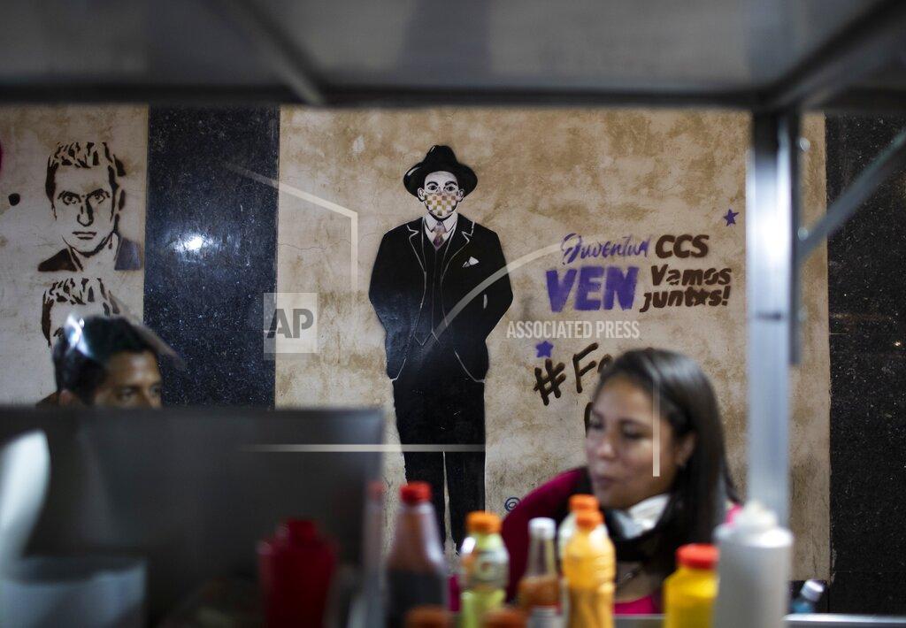 Ariana Cubillos An image of Venezuelan popular saint, Dr. Jose Gregorio Hernandez wearing a mask is seen on a wall in downtown Caracas, Venezuela, Monday, April 26, 2021. Known as the doctor of the poor, Hernandez is set to be beatified by the Catholic church, a step towards sainthood, on April 30th. (AP Photo/Ariana Cubillos)