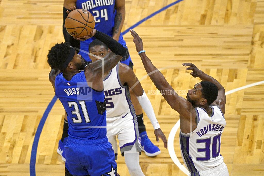 Phelan M. Ebenhack Orlando Magic guard Terrence Ross (31) shoots in front of Sacramento Kings guard De'Aaron Fox (5) and forward Glenn Robinson III (30) during the second half of an NBA basketball game Wednesday, Jan. 27, 2021, in Orlando, Fla. (AP Photo/Phelan M. Ebenhack)