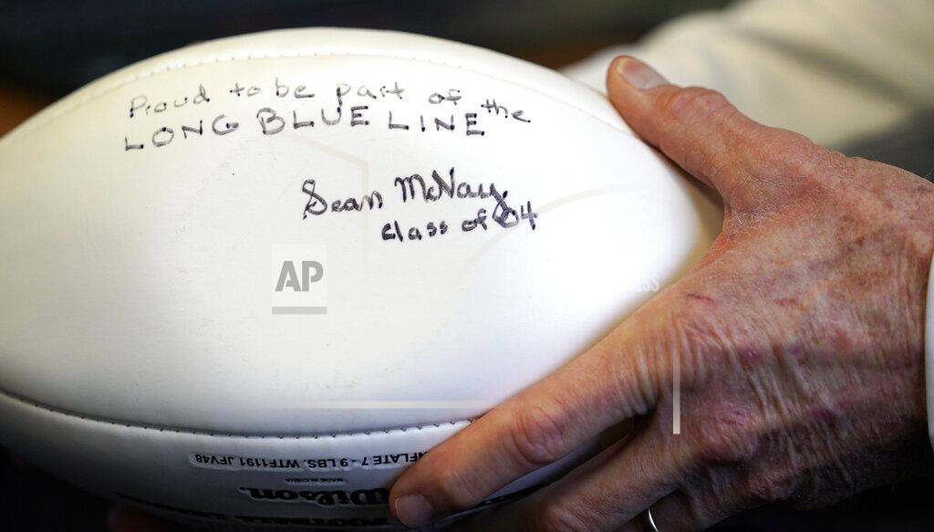 David J. Phillip Marist School football coach Alan Chadwick holds an autographed football by Los Angeles Rams coach Sean McVay as he talks about McVay's high school career at Marist during an interview for the NFL Super Bowl 53 football game Friday, Feb. 1, 2019, in Atlanta. McVay was the starting quarterback his senior year at Marist when the team won the state championship in 2003. (AP Photo/David J. Phillip)