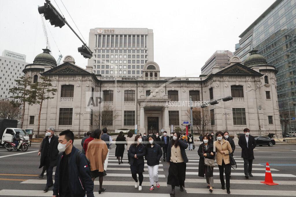 Ahn Young-Joon People wearing face masks walk by the headquarters of the Bank of Korea in Seoul, South Korea, Thursday, March 4, 2021. South Korea's central bank says the country's economy shrank for the first time in 22 years in 2020 as the coronavirus pandemic destroyed service industry jobs and depressed consumer spending. (AP Photo/Ahn Young-joon)