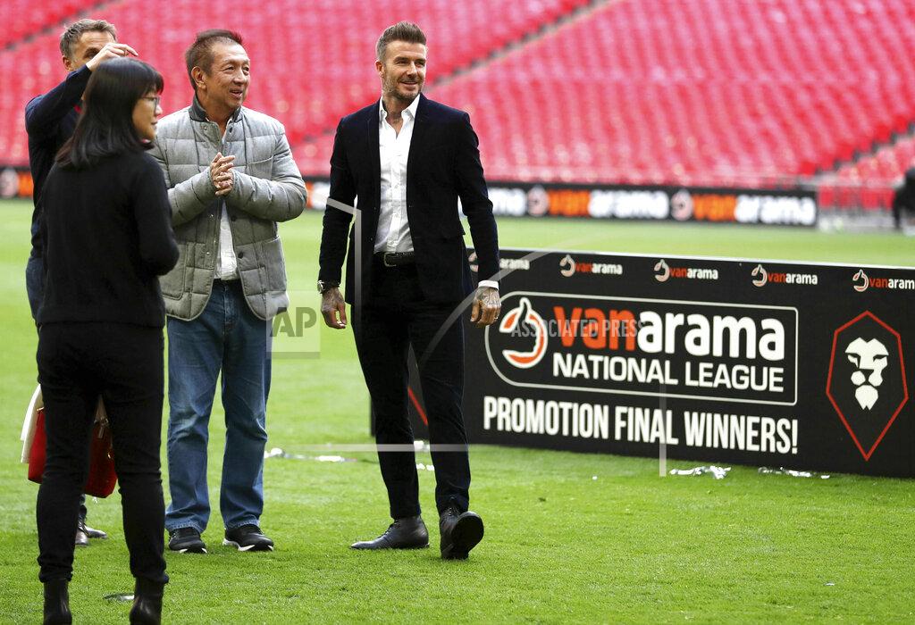 Bradley Collyer Salford City co-owner David Beckham, right, on the pitch after the National League Play-off Soccer Final at Wembley Stadium, London, Saturday, May 11, 2019. David Beckham watched on at Wembley as Salford secured their Football League place with a 3-0 win over AFC Fylde in the Vanarama National League play-off final. The former England captain joined some of his fellow co-owners from Manchester United's 'Class of 92' to cheer on Graham Alexander's side as the club secured promotion to the Football League for the first time. (Bradley Collyer/PA via AP)