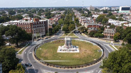 FILE - The pedestal that once held the statue of Confederate General Robert E. Lee stands empty on Monument Avenue in Richmond, Va., Tuesday, Sept. 14, 2021. The pedestal has been covered in graffiti, with some describing it as a work of protest art that should be left in place. (AP Photo/Steve Helber, File)