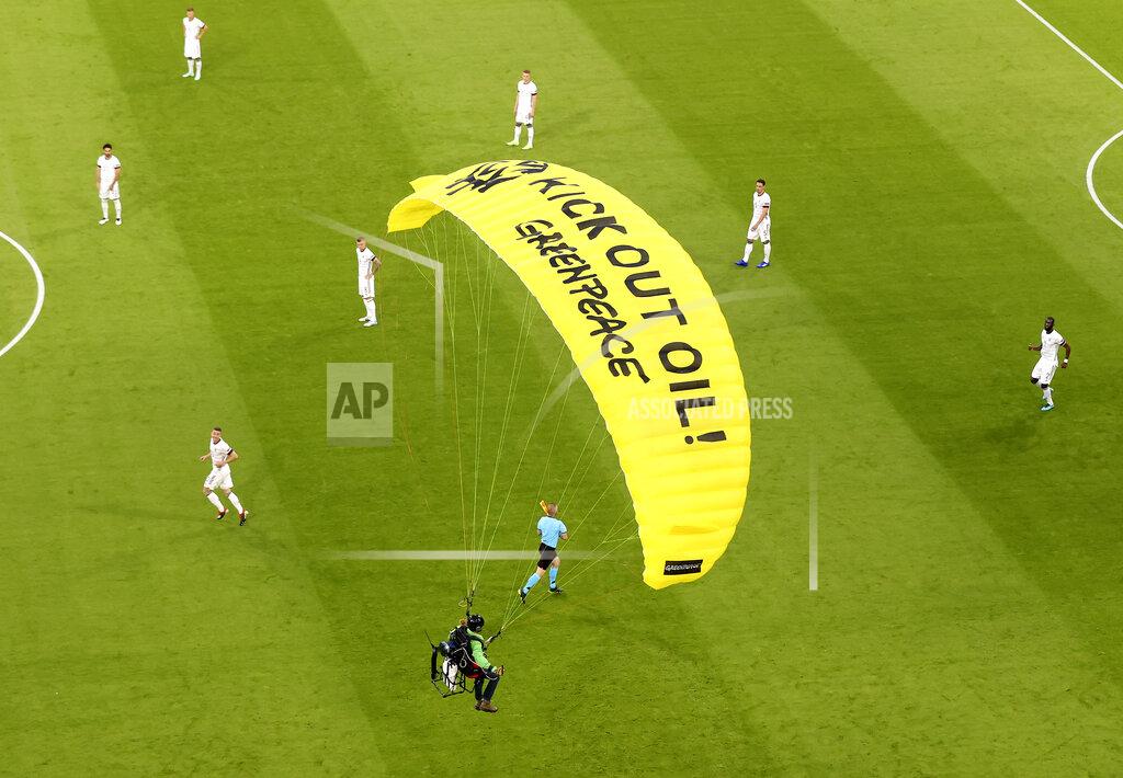 Alexander Hassenstein The German players look on as a Greenpeace paraglider lands in the stadium prior to the Euro 2020 soccer championship group F match between France and Germany at the Allianz Arena stadium in Munich, Tuesday, June 15, 2021. (AP Photo/ctivist Alexander Hassenstein, Pool)