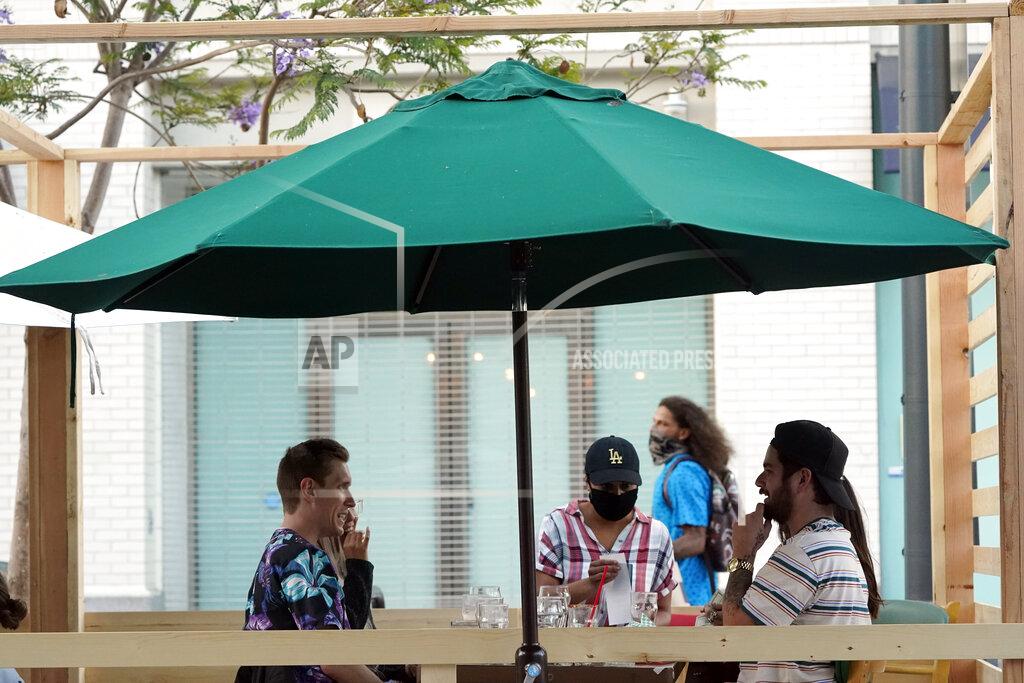 Marcio Jose Sanchez A server tends to customers in an outdoor dining area amid the COVID-19 pandemic on The Promenade Wednesday, June 9, 2021, in Santa Monica, Calif. (AP Photo/Marcio Jose Sanchez)