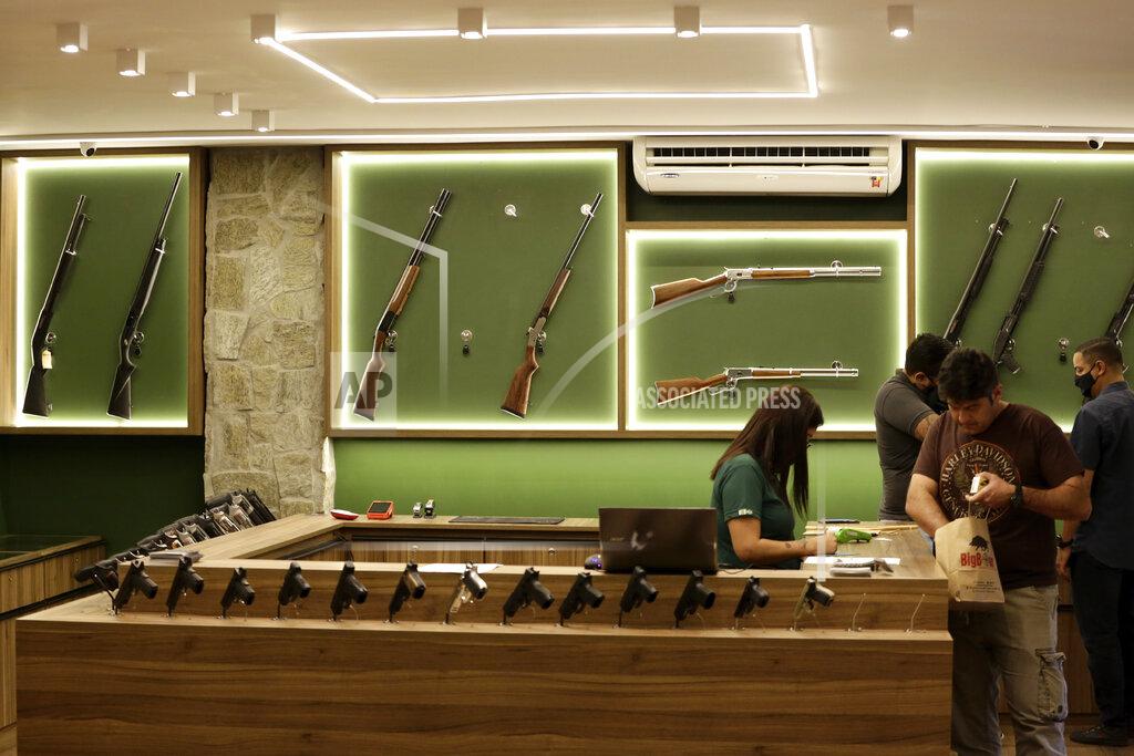 Eraldo Peres An employee waits on a customer in a Big Boar gun shop in Brasilia, Brazil, Thursday, March 4, 2021. A poll by pollster Ibope published in July 2019, only months after President Jair Bolsonaro’s inauguration, showed that 73% want strict gun control laws. (AP Photo/Eraldo Peres)