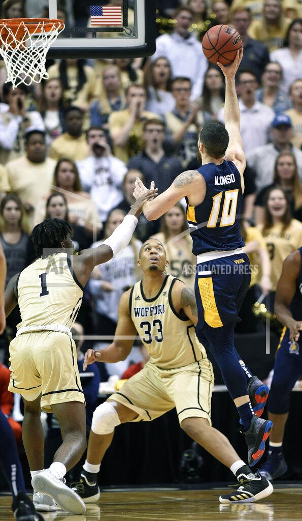 Kathy Kmonicek UNC-Greensboro guard Francis Alonso (10) drives to the basket over Wofford forwards Chevez Goodwin (1) and Cameron Jackson (33) in the first half of an NCAA college basketball game for the Southern Conference tournament championship, Monday, March 11, 2019, in Asheville, N.C. (AP Photo/Kathy Kmonicek)