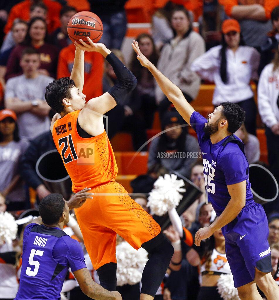 Nate Billings Oklahoma State's Lindy Waters III (21) shoots between TCU's Alex Robinson (25), right, and Kendric Davis (5) in the second half of a NCAA college basketball game in Stillwater, Okla., Monday, Feb. 18, 2019. (Nate Billings/The Oklahoman via AP)