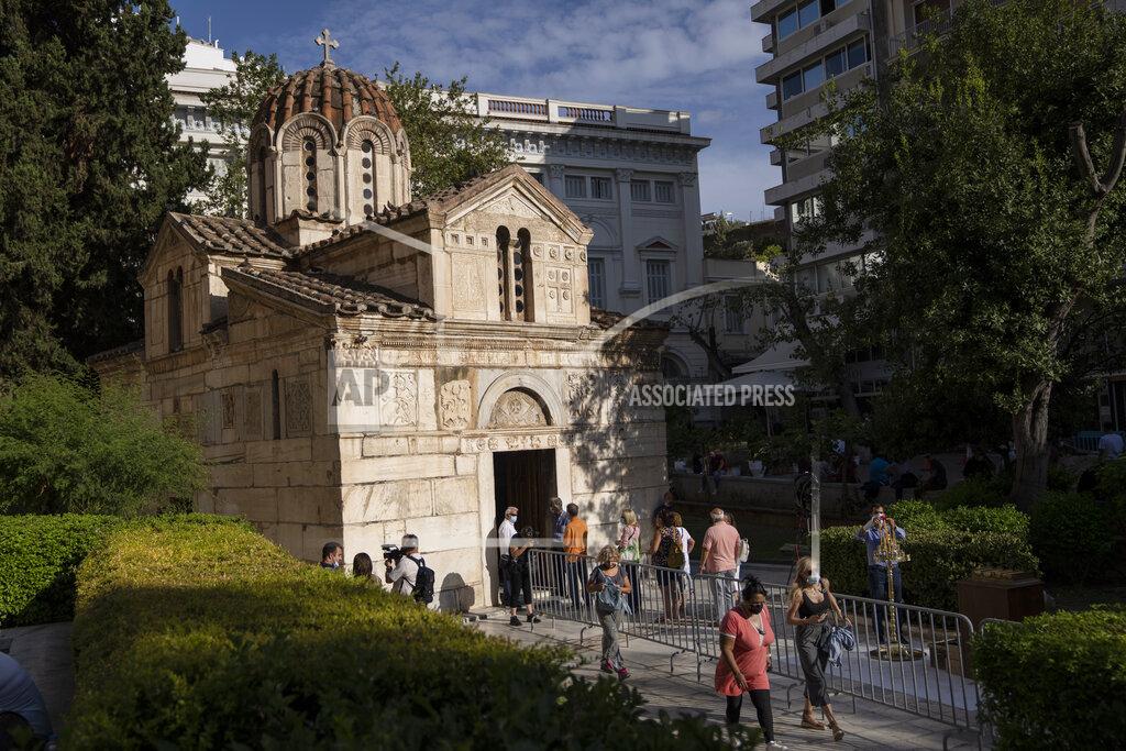 Petros Giannakouris People wait outside a chapel of the Athens Cathedral to pay respect to the late Greek composer Mikis Theodorakis in Athens on Monday Sept. 6, 2021. Hundreds of people have gathered outside Athens Cathedral where Greek composer and politician Mikis Theodorakis is to lie in state in a chapel of the cathedral for three days ahead of his burial on the southern island of Crete. (AP Photo/Petros Giannakouris)