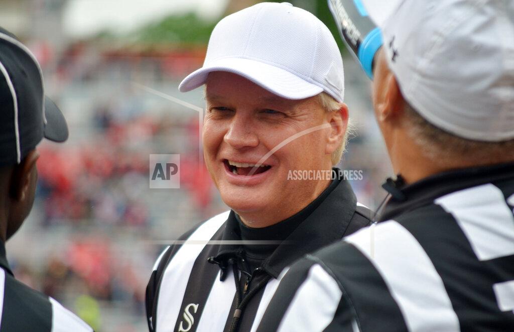 In this April 20, 2019, photo, Steve Shaw talks with a colleagues during Georgia's spring NCAA college football game in Athens, Ga. Officials are graded weekly on every play and those grades ultimately determine what conference they work. SEC officials have often worked their way up from the Sun Belt. Bowl assignments are determined by regular-season grades and poor grades can lead to demotions. Shaw, the national coordinator of football officials and the SEC’s head of officiating, said last week at the conference spring meetings that eight officials won’t be returning to the SEC this season. One moved on to the NFL and seven either retired or were not retained, Shaw said, declining to elaborate. (Gary McGriff via AP)