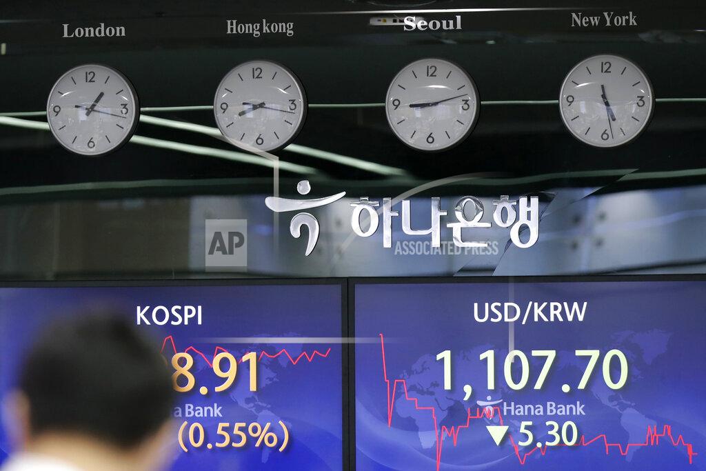 Lee Jin-Man A currency trader walks near the screens showing the Korea Composite Stock Price Index (KOSPI), left, and the foreign exchange rate between U.S. dollar and South Korean won at the foreign exchange dealing room in Seoul, South Korea, Thursday, April 29, 2021. Asian shares rose Thursday and U.S. futures also were higher after President Joe Biden delivered a speech to Congress that outlined ambitious plans for jobs creating spending on early education, child care and other public services.(AP Photo/Lee Jin-man)