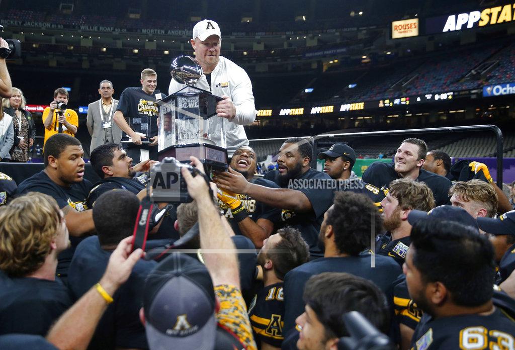 Gerald Herbert Appalachian State interim head coach Mark Ivey hands the bowl trophy to his team after the New Orleans Bowl NCAA college football game against Middle Tennessee in New Orleans, Saturday, Dec. 15, 2018. Appalachian State won 45-13. (AP Photo/Gerald Herbert)
