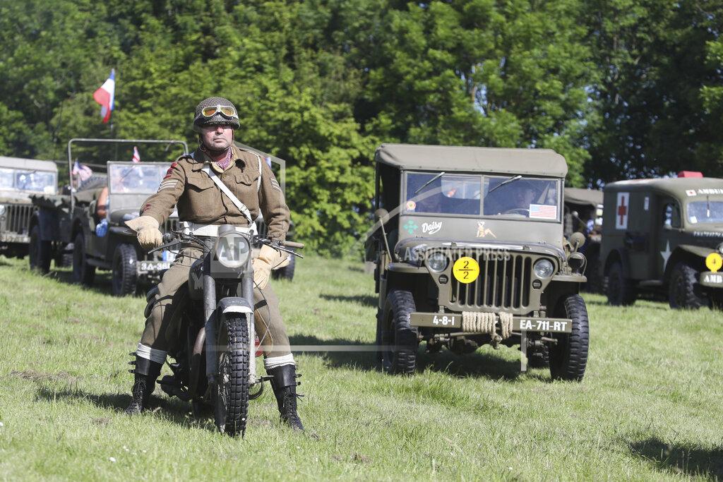 David Vincent World War II history enthusiasts parade in WWII vehicles in Colleville-Montgomery,, Normandy, Saturday June, 5 2021 on the eve of 77th anniversary of the assault that helped bring an end to World War II. While France is planning to open up to vaccinated visitors starting next week, that comes too late for the D-Day anniversary. So for the second year in a row, most public commemoration events have been cancelled. A few solemn ceremonies have been maintained, in the presence of dignitaries and a few guests only. (AP Photo/David Vincent)