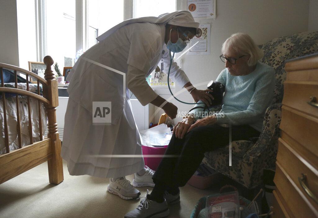 Jessie Wardarski Sister Rose Nellivila checks the blood pressure of Lorraine Catney, a resident of Villa Angela at St. Anne Home nursing facility in Greensburg, Pa., Thursday, March 25, 2021. (AP Photo/Jessie Wardarski)
