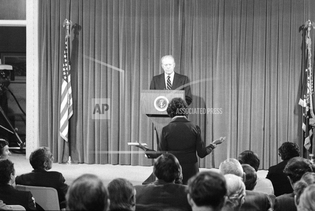 Anonymous FILE - In this Oct. 9, 1975, file photo President Gerald Ford listens to a news reporter's question during a news conference at the Executive Office building in Washington. It was Ford's first live nationally broadcast news conference since June 24. (AP Photo, File)