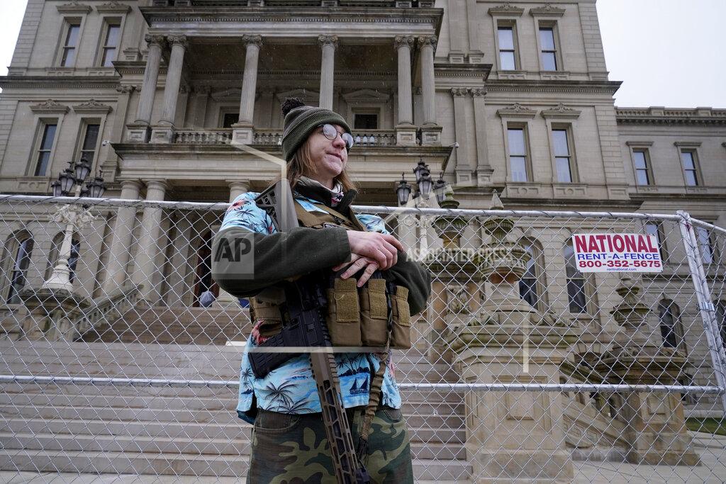 Paul Sancya Timothy Teagan, a member of the Boogaloo Bois movement, stands with his rifle outside the state capitol in Lansing, Mich., Sunday, Jan. 17, 2021. (AP Photo/Paul Sancya)