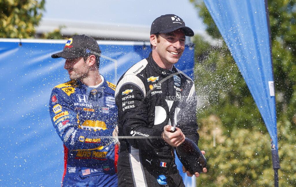 Mark Blinch Simon Pagenaud, right, of France, celebrates in the Winner's Circle after taking first place at the Honda Indy auto race in Toronto, Sunday, July 14, 2019. (Mark Blinch/The Canadian Press via AP)