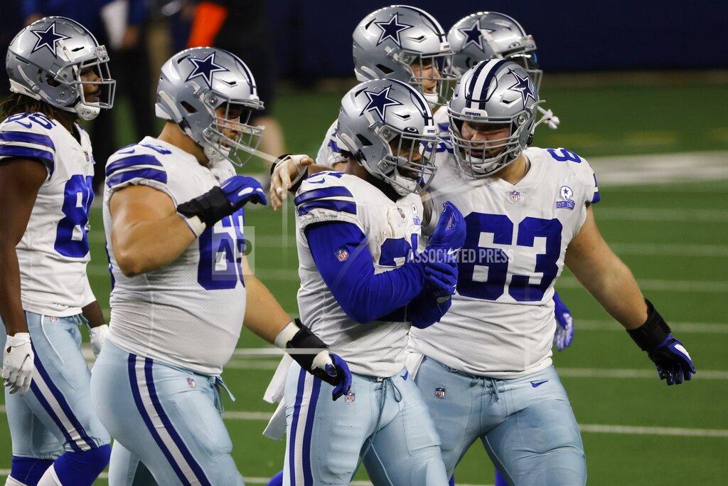 Ron Jenkins Dallas Cowboys' Brandon Knight (69) and Tyler Biadasz (63) walk off the field with running back Ezekiel Elliott (21) after Elliott fumbled the ball on a carry against the Arizona Cardinals in the first half of an NFL football game in Arlington, Texas, Monday, Oct. 19, 2020. (AP Photo/Ron Jenkins)