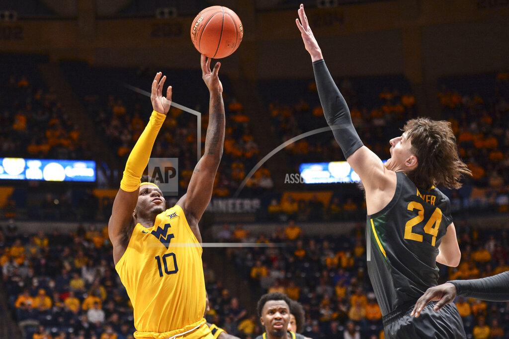 William Wotring West Virginia guard Malik Curry (10) shoots while being guarded by Baylor guard Matthew Mayer (24) during the first half of an NCAA college basketball game in Morgantown, W.Va., Tuesday, Jan. 18, 2022. (William Wotring)