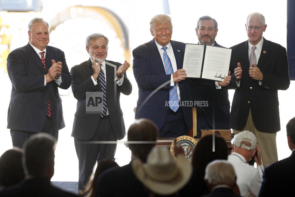 Tony Gutierrez President Donald Trump holds up a permit for energy development after signing it during a visit to the Double Eagle Energy Oil Rig, Wednesday, July 29, 2020, in Midland, Texas. Sen. Ted Cruz, R-Texas, stands rear, second from right. (AP Photo/Tony Gutierrez)