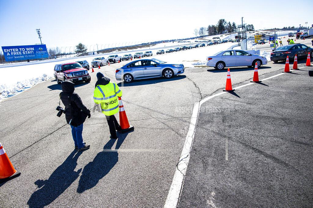 Geoff Forester New Hampshire state officials monitor traffic as residents make their way off the track at the New Hampshire Motor Speedway to get vaccinated on Saturday morning, March 6, 2021, in Loudon, N.H. The state was hoping to have 12,000 people vaccinated at the track by Monday afternoon. (Geoff Forester/The Concord Monitor via AP)