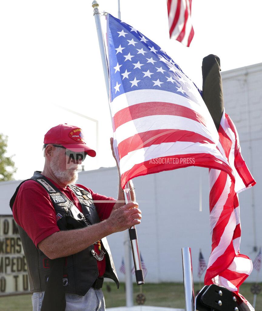 Nikos Frazier Jim Jamison of Westfield, Ind. unfurls a flag to place at the back of his motorcycle before the funeral procession for Marine Cpl. Humberto Sanchez, Tuesday, Sept. 14, 2021 in Logansport, Ind. Sanchez was one of 13 U.S. service members to die in an explosion during evacuation efforts in Afghanistan. (Nikos Frazier/Journal & Courier via AP)
