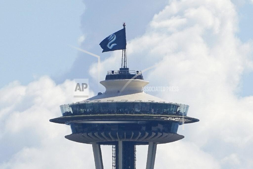 Ted S. Warren The Seattle Kraken NHL hockey flag flies on top of the Space Needle, Wednesday, July 21, 2021, before the Kraken's expansion draft event. (AP Photo/Ted S. Warren)