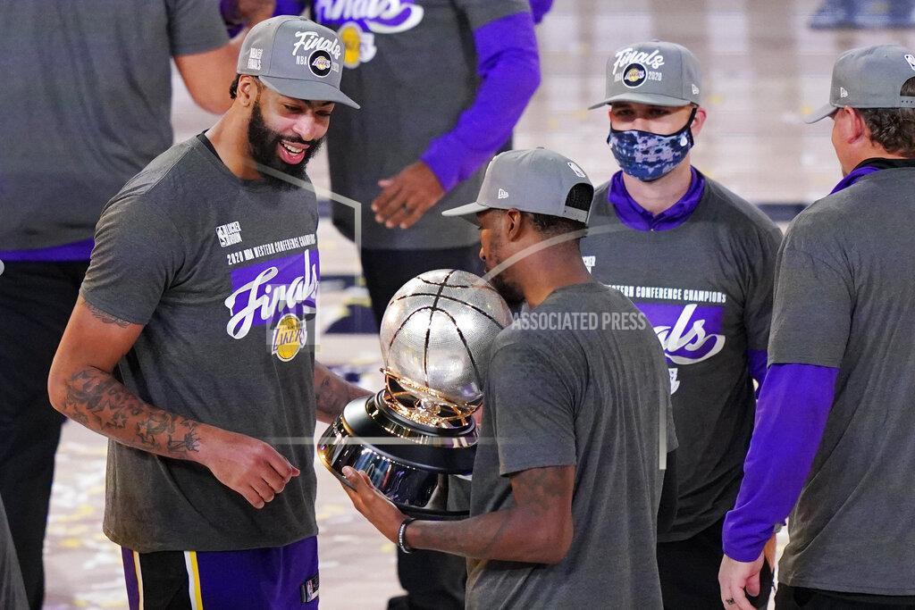 Mark J. Terrill Los Angeles Lakers' Anthony Davis, left, looks at their trophy after beating the Denver Nuggets in an NBA conference final playoff basketball game Saturday, Sept. 26, 2020, in Lake Buena Vista, Fla. The Lakers won 117-107 to win the series 4-1. (AP Photo/Mark J. Terrill)