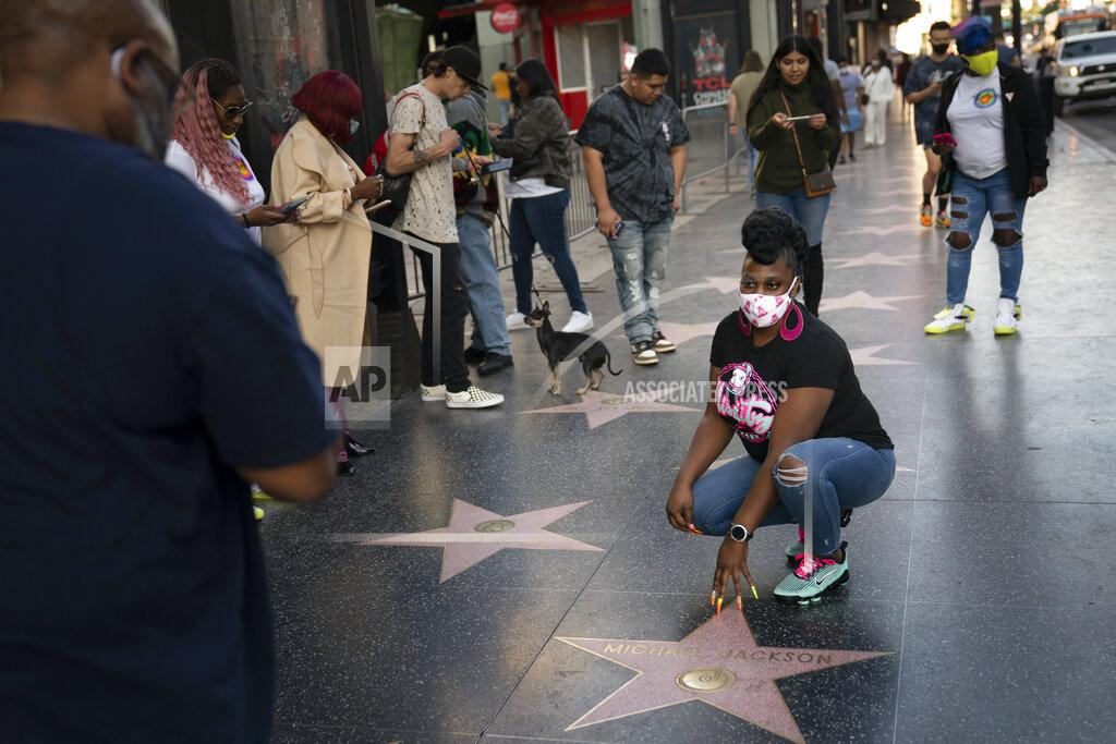 Jae C. Hong A tourist in a face mask pauses for photos with Michael Jackson's star on the Hollywood Walk of Fame in Los Angeles, Thursday, Nov. 12, 2020. California has become the second state to record 1 million confirmed coronavirus infections. (AP Photo/Jae C. Hong)