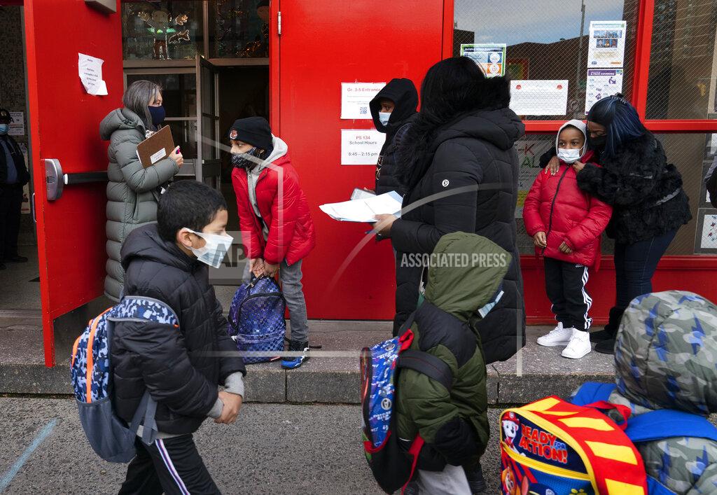 Mark Lennihan Students enter P.S. 134 Henrietta Szold Elementary School, Monday, Dec. 7, 2020, in New York. Public schools reopened for in-school learning Monday after being closed since mid-November. (AP Photo/Mark Lennihan)
