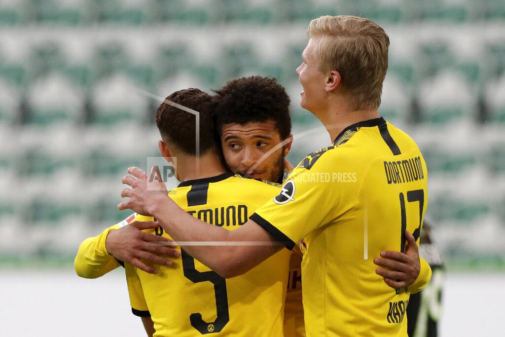 Michael Sohn Dortmund's Achraf Hakimi, left, celebrates with Jadon Sancho and Erling Haaland, right, after scoring his side's second goal during the German Bundesliga soccer match between VfL Wolfsburg and Borussia Dortmund in Wolfsburg, Germany, Saturday, May 23, 2020. The German Bundesliga is the world's first major soccer league to resume after a two-month suspension because of the coronavirus pandemic. (AP Photo/Michael Sohn, Pool)